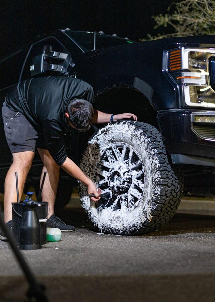 Obsidian detailer polishing a truck wheel during a mobile detail near Baltimore